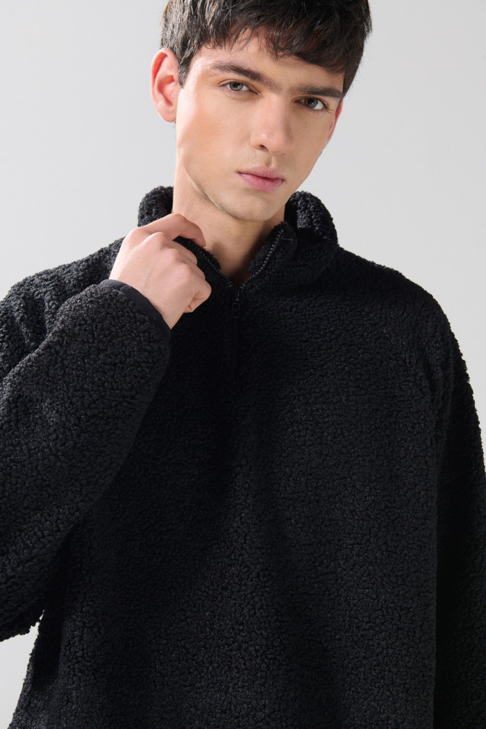 Buzo negro con cuello alto, cremallera y manga larga