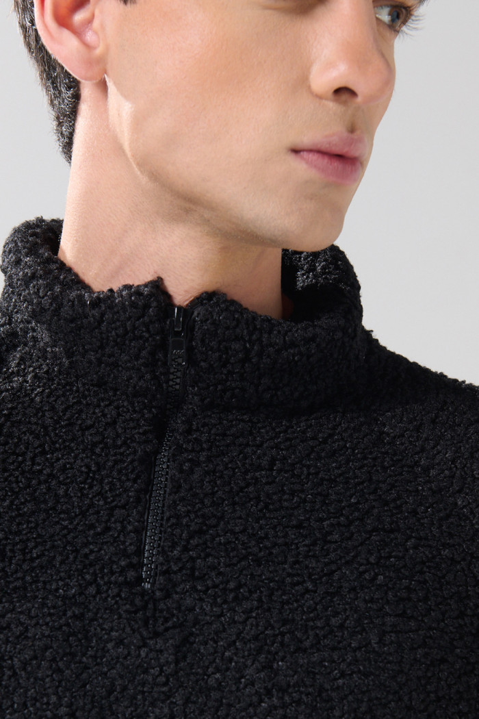 Buzo negro con cuello alto, cremallera y manga larga