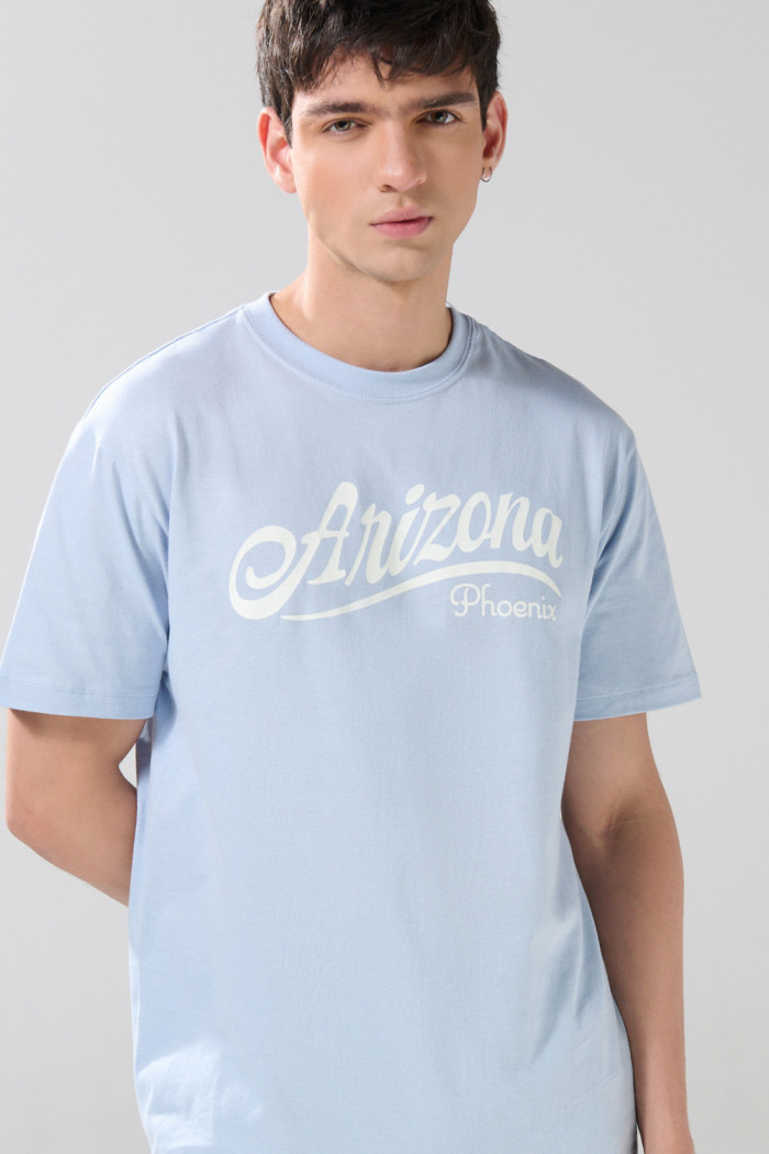 Camiseta manga corta azul clara con texto college blanco