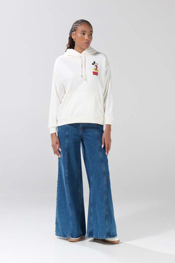 Buzo crema con capota oversize y arte de Mickey
