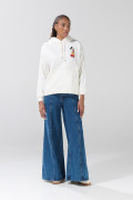 Buzo crema con capota oversize y arte de Mickey
