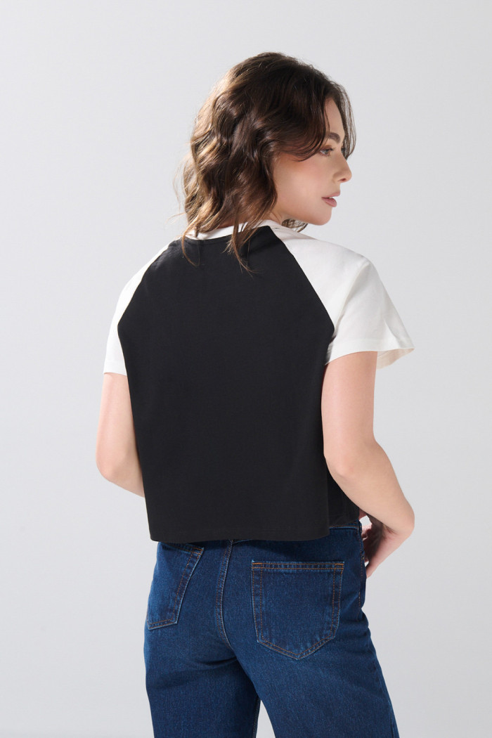 Camiseta negra crop top college con manga ranglan blanca