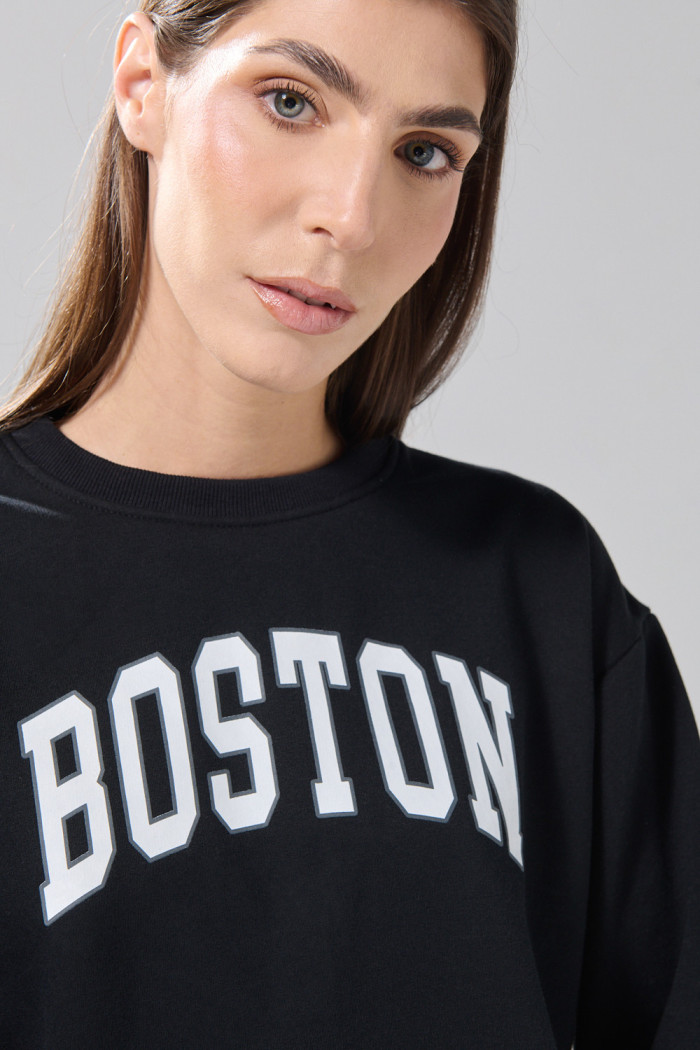 Buzo negro con texto college y cuello redondo