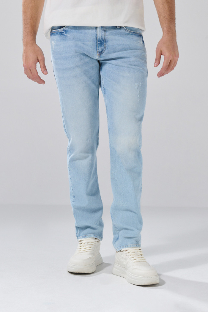 Jean slim infaltables azul claro con desgastes y tiro bajo

