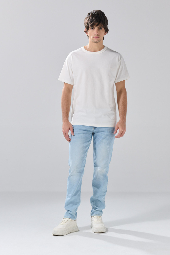 Jean slim infaltables azul claro con desgastes y tiro bajo
