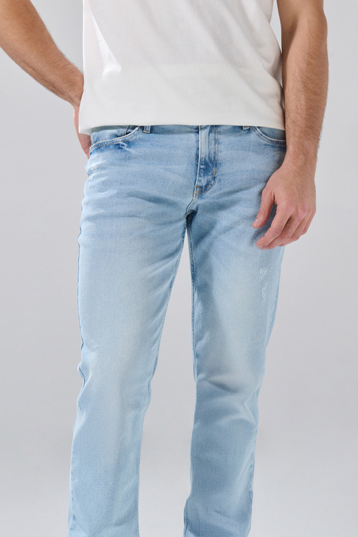 Jean slim infaltables azul claro con desgastes y tiro bajo
