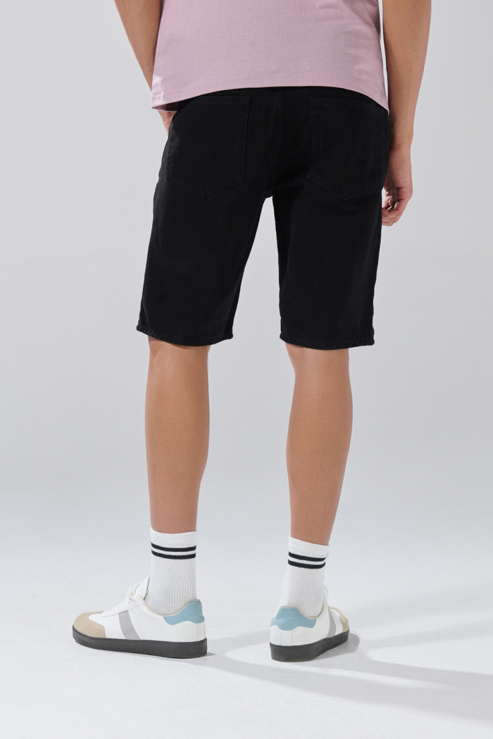 Bermuda negra de jean slim tiro bajo con bolsillos
