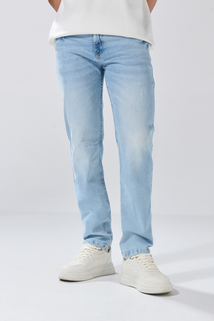 Jean slim azul claro tiro bajo con desgastes y botón
