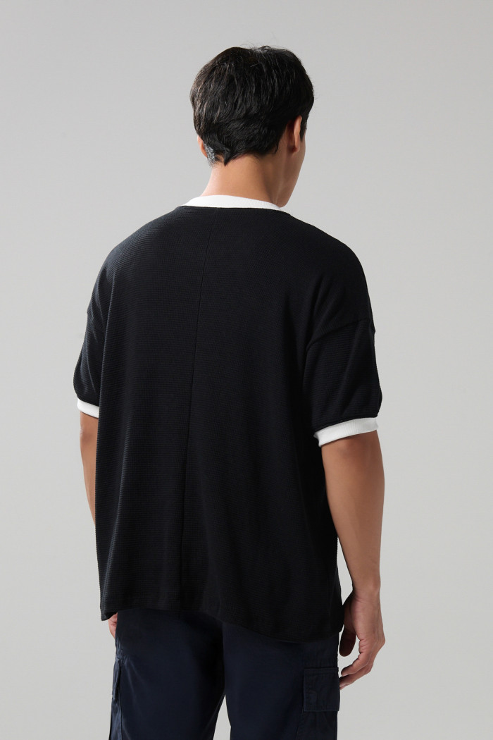 Camiseta oversize negra cuello V con diseños college
