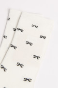 Medias unicolores largas con diseños de moños
