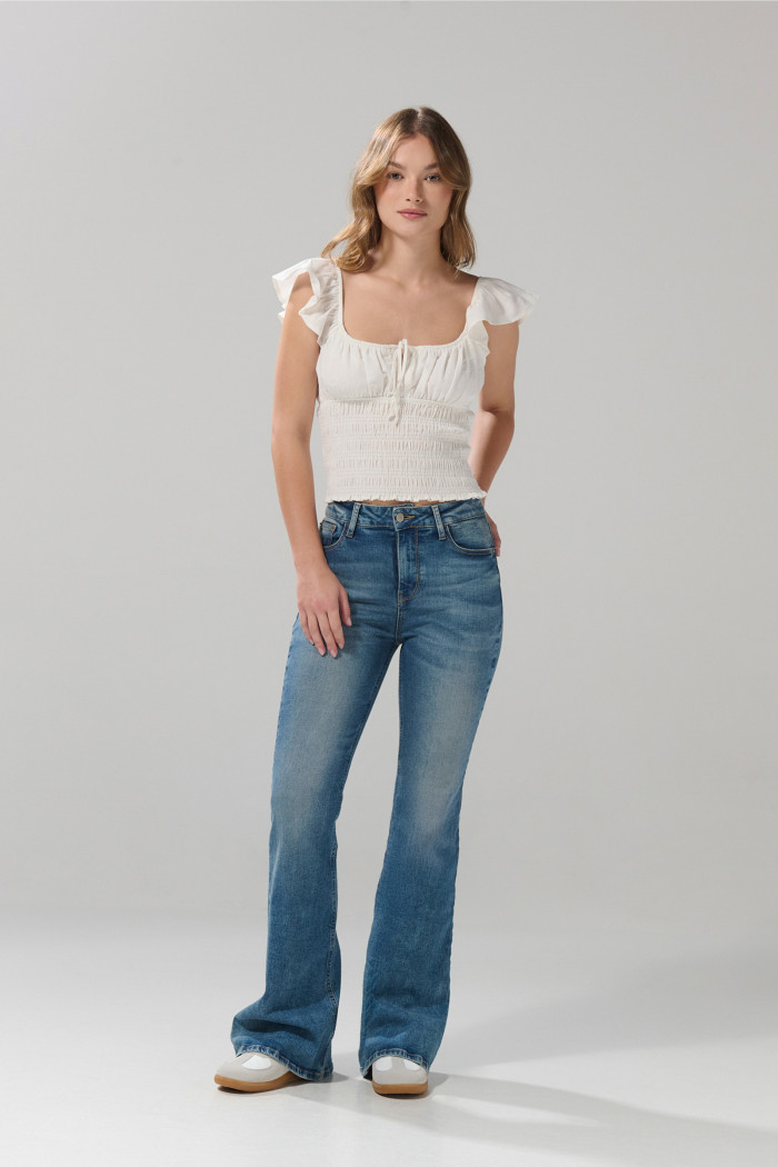 Jean flare azul claro con bota ancha, bolsillos y tiro alto
