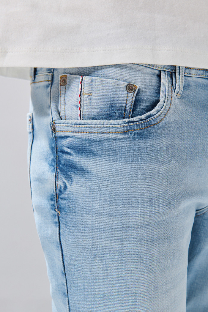 Jean skinny con 5 bolsillos azul claro, desgastes y tiro bajo