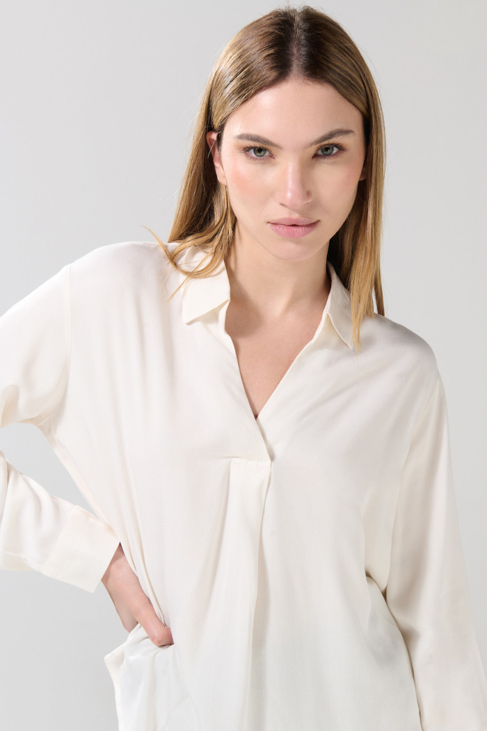Blusa unicolor con manga larga y charreteras