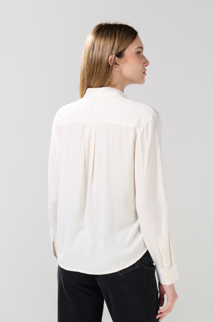 Blusa unicolor con manga larga y charreteras
