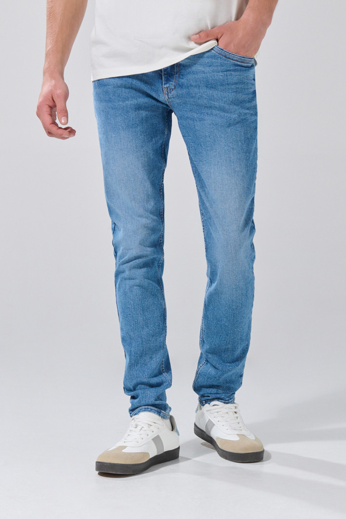 Jean azul medio skinny con desgastes y tiro bajo
