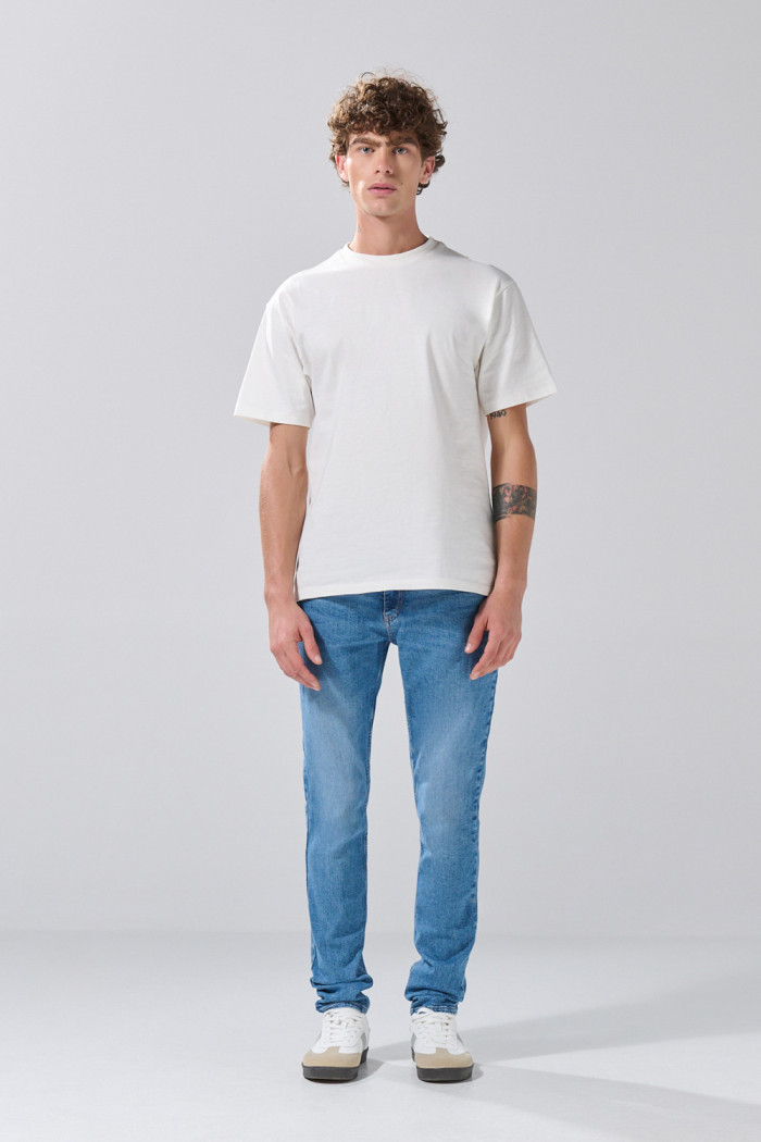 Jean azul medio skinny con desgastes y tiro bajo
