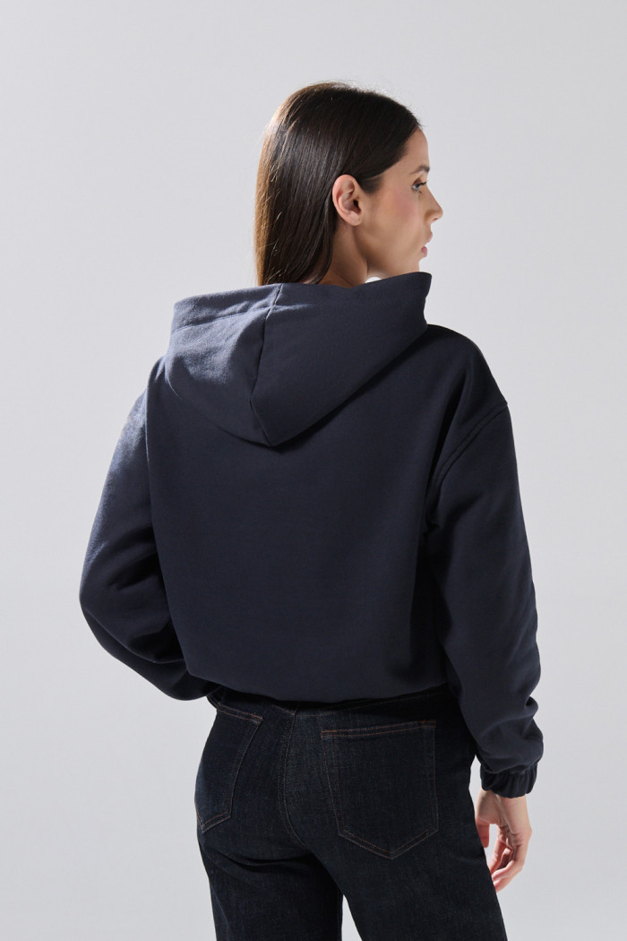 Buzo azul intenso college oversize perchado con capota