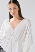 Blusa crema clara con escote en V, recogido y manga larga