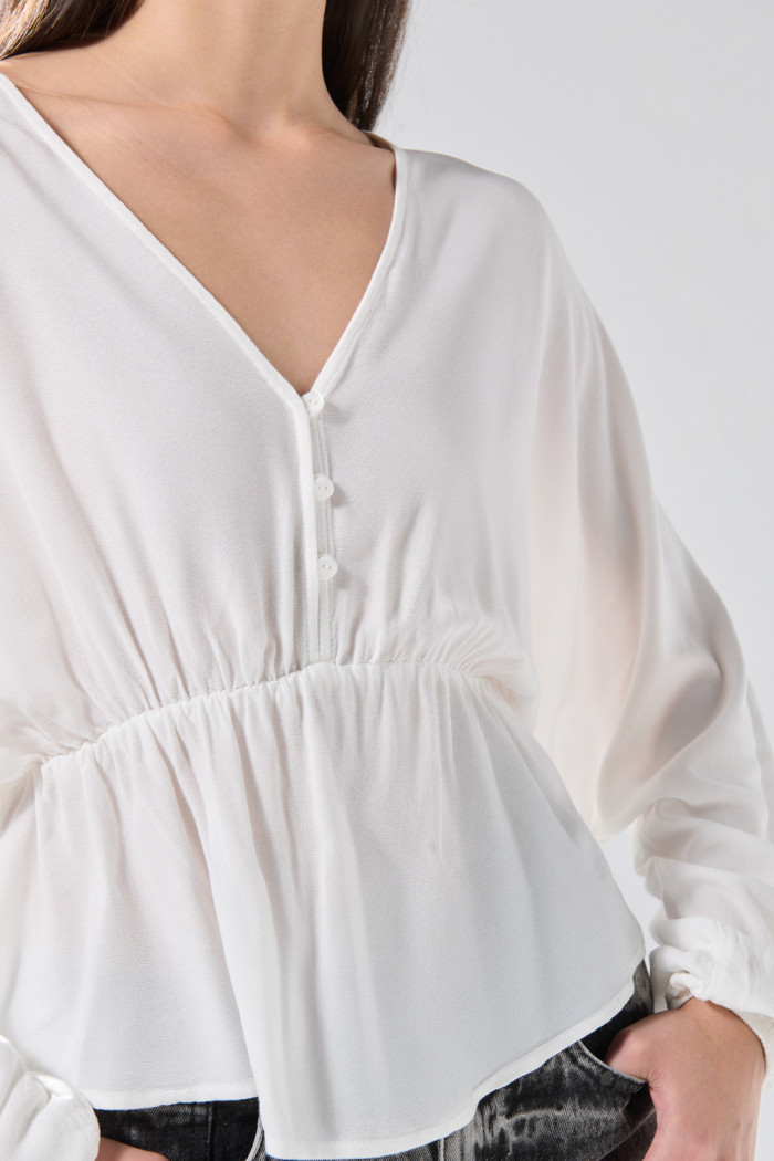 Blusa crema clara con escote en V, recogido y manga larga