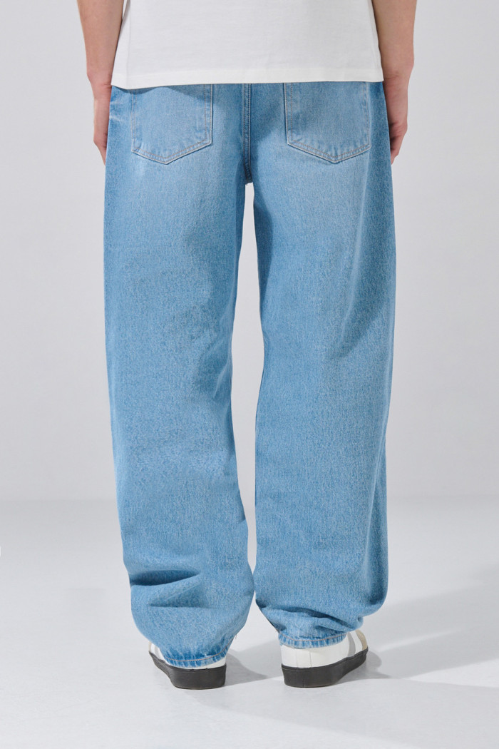 Jean baggy tiro medio azul con bota ancha y desgastes
