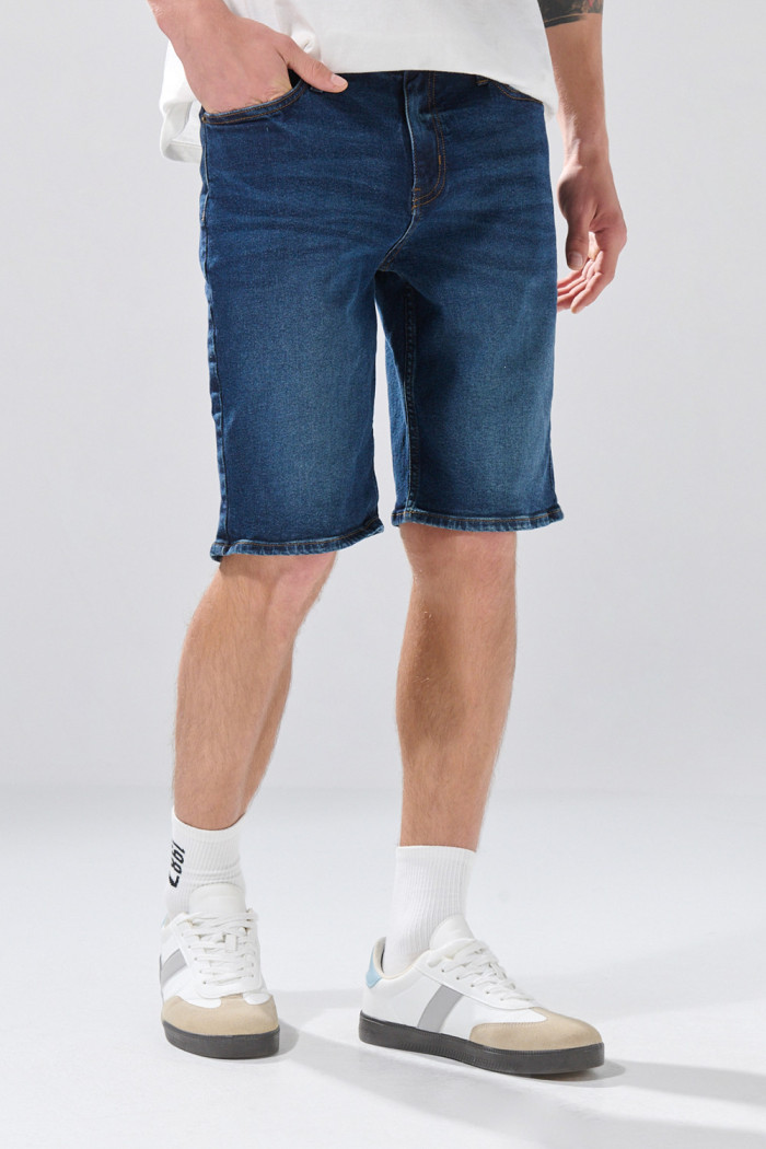 Bermuda azul de jean slim con tiro bajo y costuras visibles

