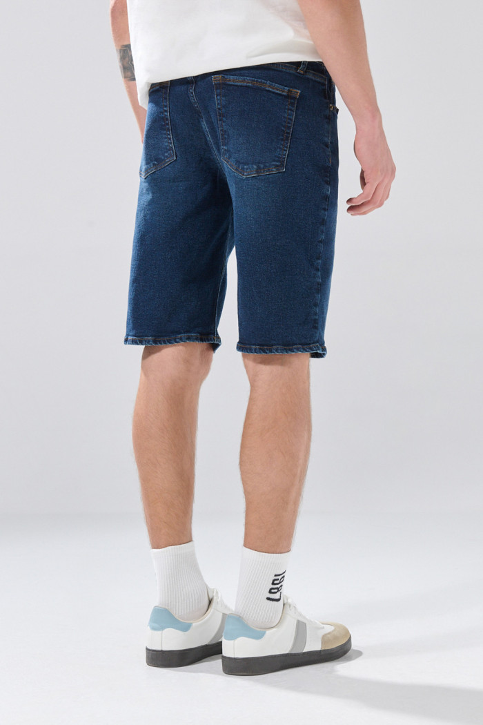 Bermuda azul de jean slim con tiro bajo y costuras visibles

