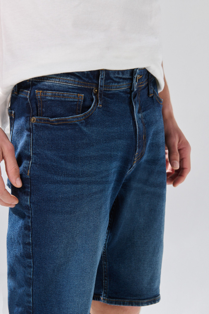 Bermuda azul de jean slim con tiro bajo y costuras visibles
