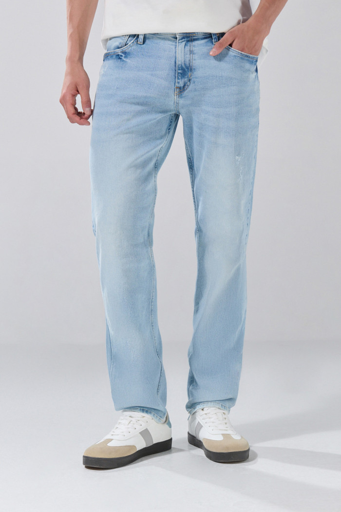 Jean slim azul claro con tiro bajo, bolsillos y desgastes
