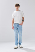 Jean slim azul claro con desgastes ligeros y tiro bajo
