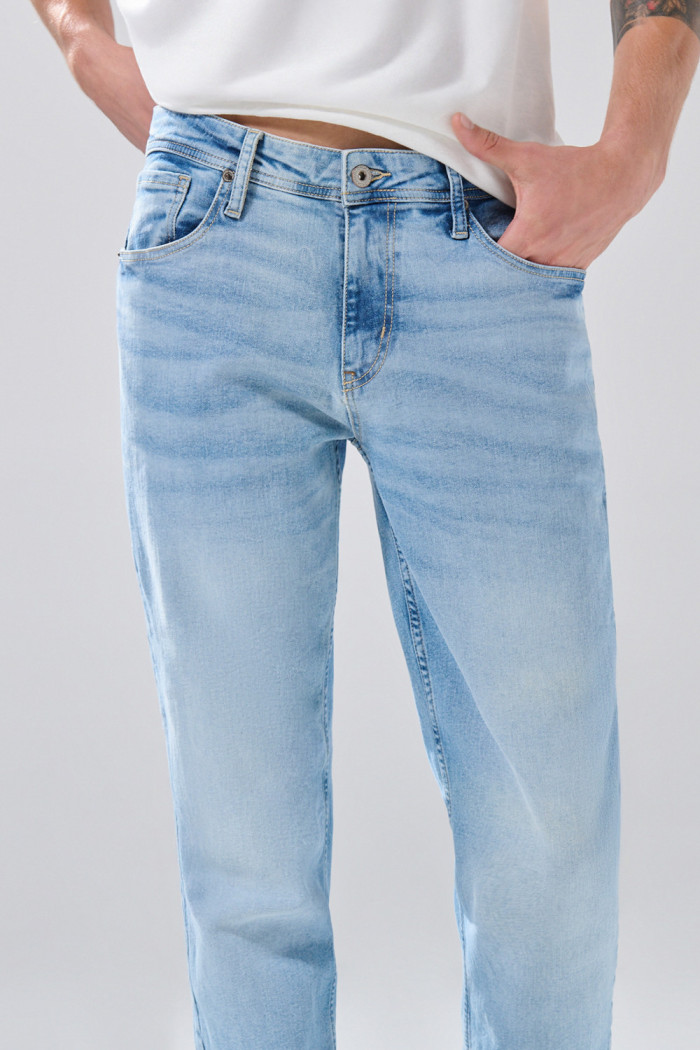 Jean slim azul claro con desgastes ligeros y tiro bajo
