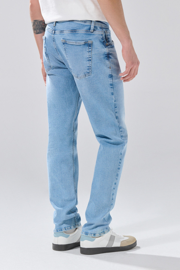 Jean slim azul claro con desgastes ligeros y tiro bajo
