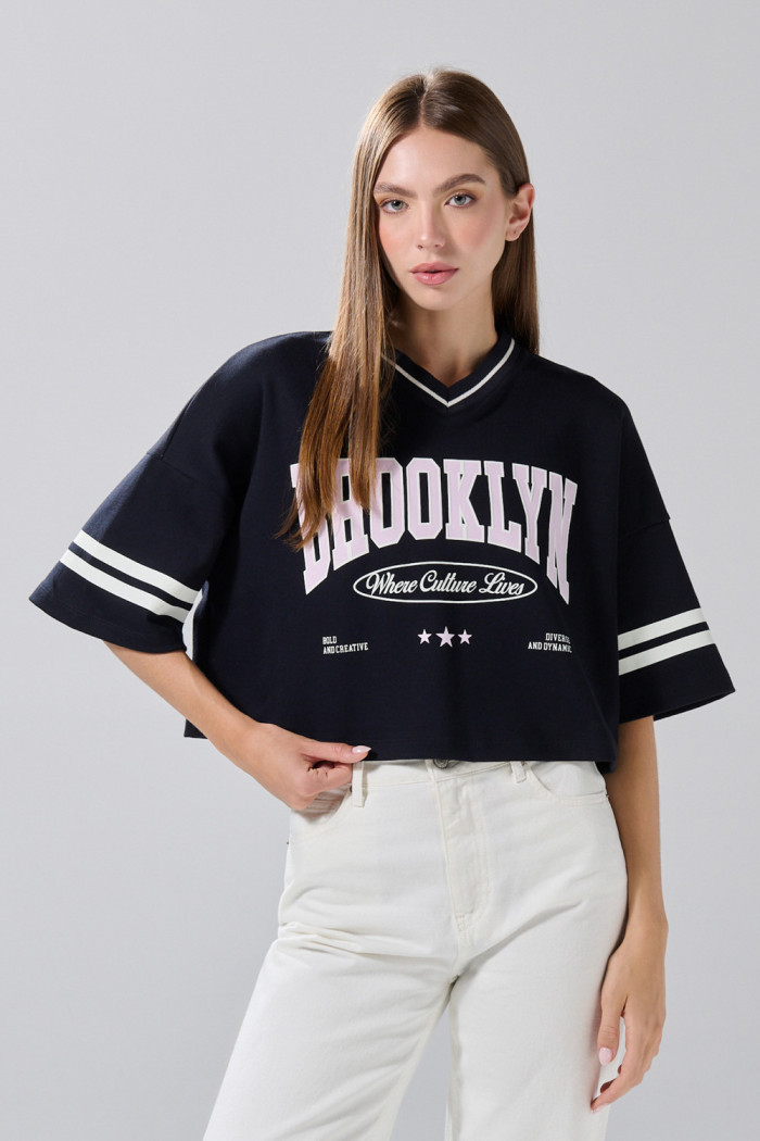 Camiseta crop top azul oversize con cuello V y arte college
