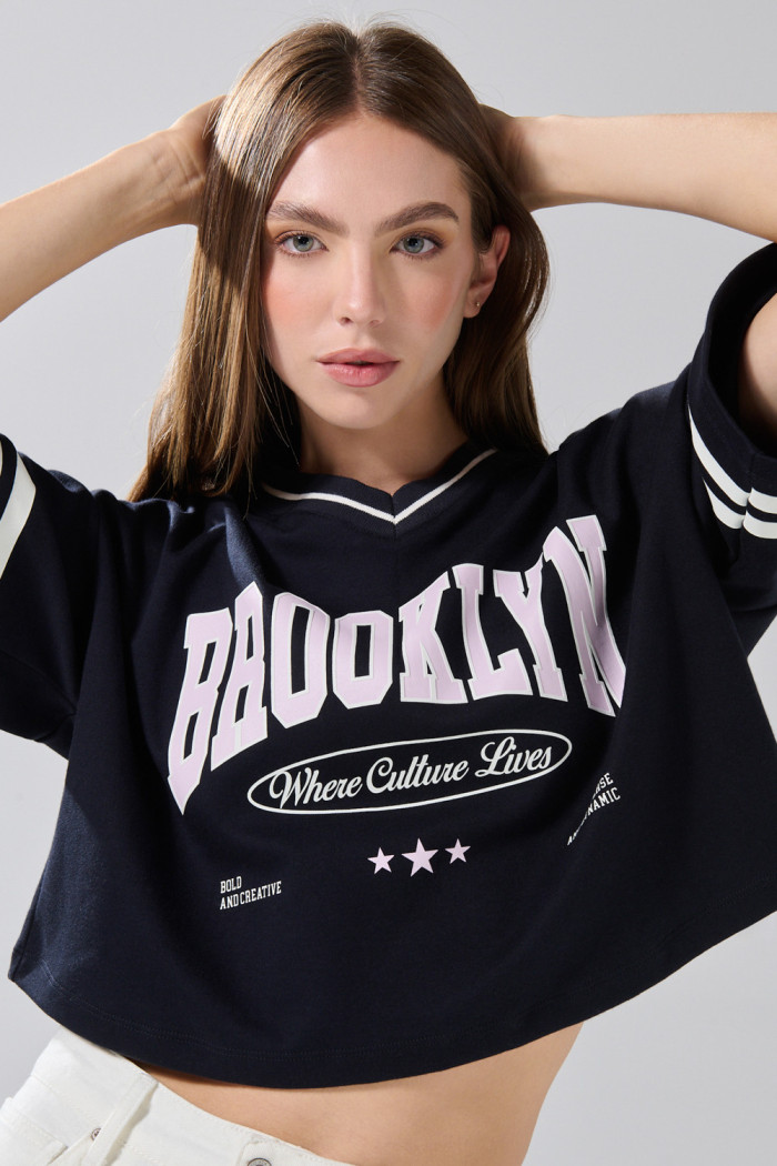 Camiseta crop top azul oversize con cuello V y arte college

