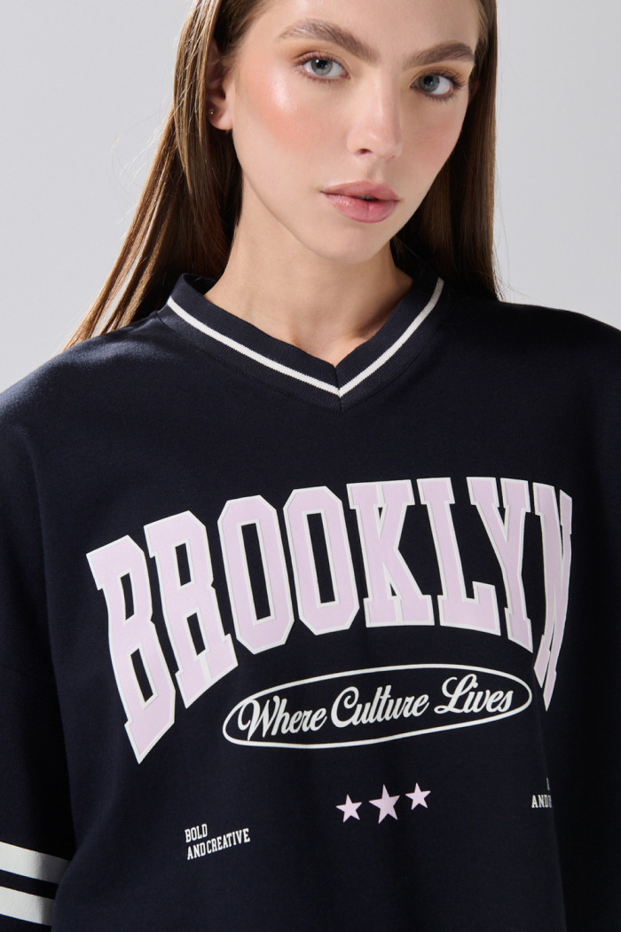 Camiseta crop top azul oversize con cuello V y arte college
