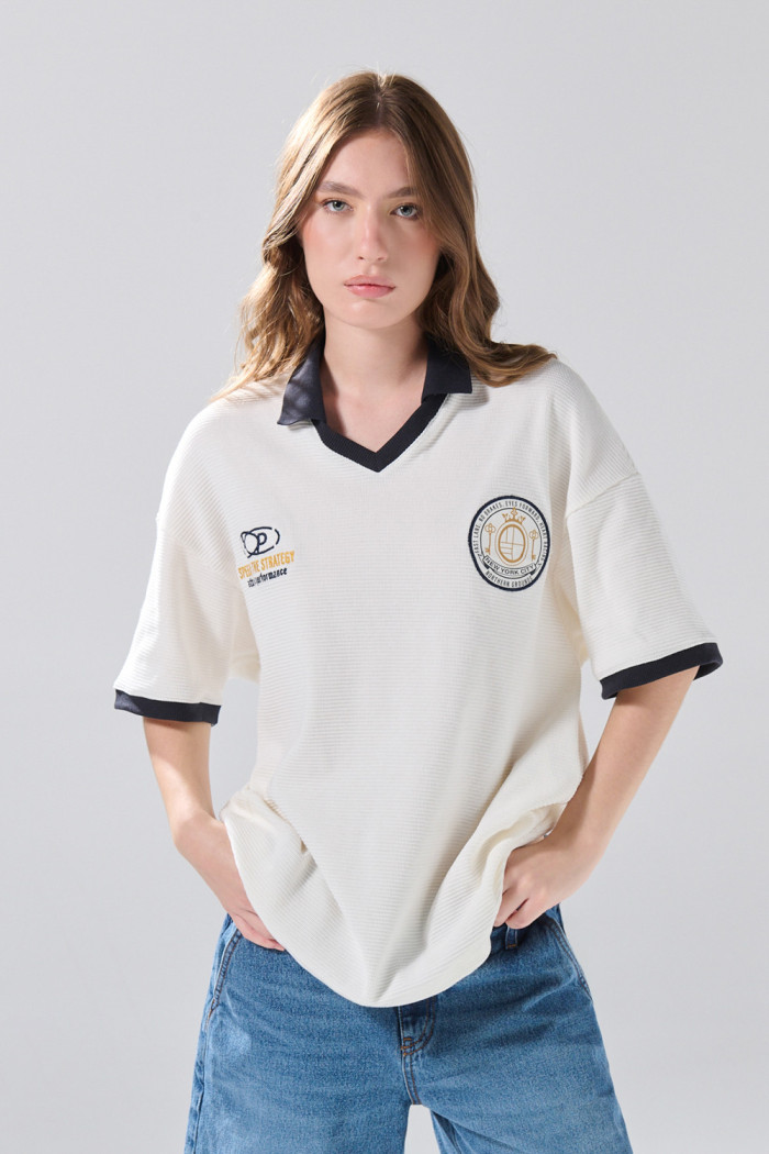 Camiseta oversize crema con cuello polo y diseños college