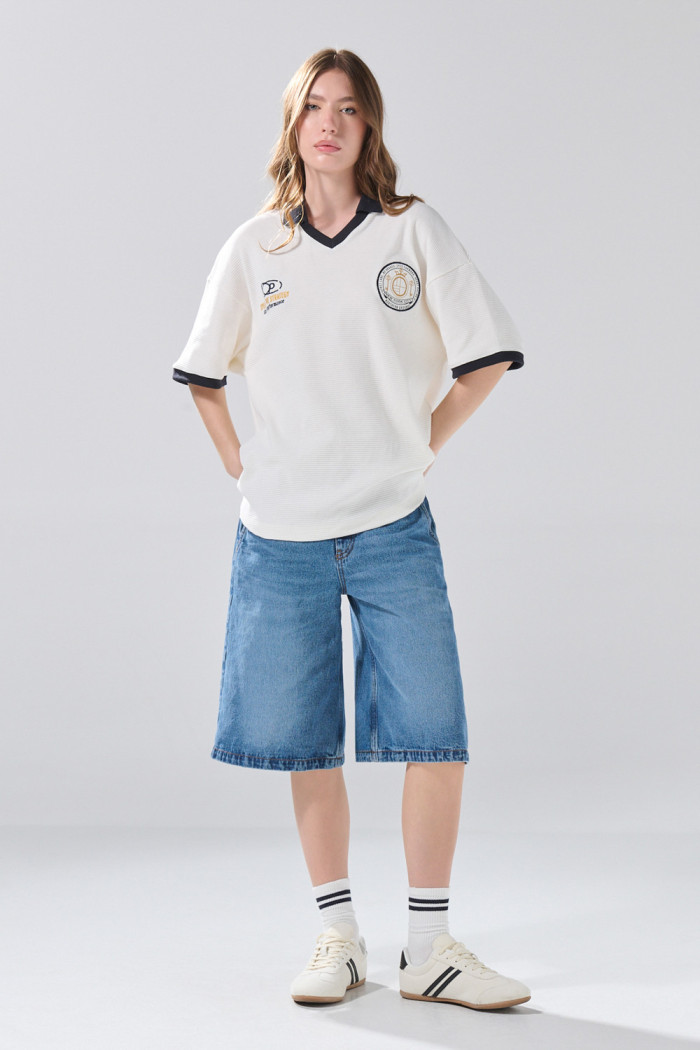 Camiseta oversize crema con cuello polo y diseños college