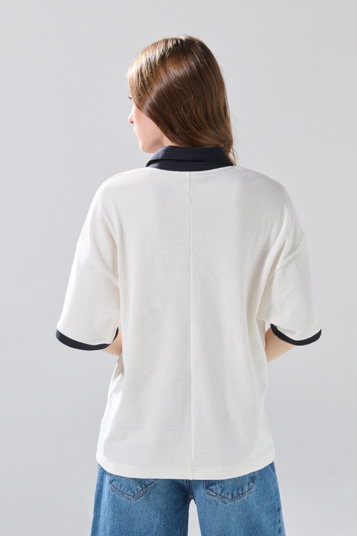 Camiseta oversize crema con cuello polo y diseños college