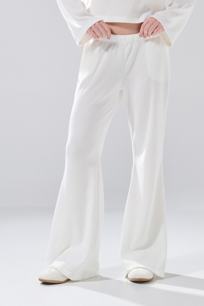 Pantalón unicolor flare con bota ancha y texturas
