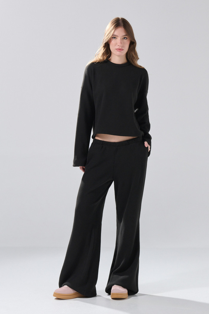 Pantalón unicolor flare con bota ancha y texturas
