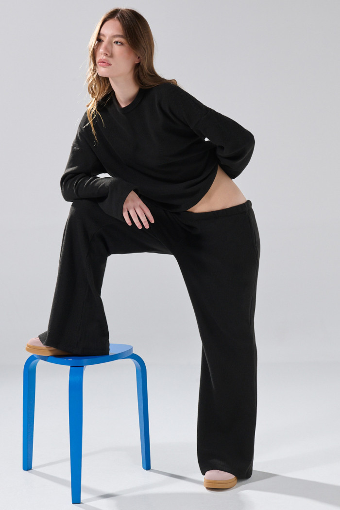 Pantalón unicolor flare con bota ancha y texturas
