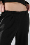 Pantalón unicolor flare con bota ancha y texturas
