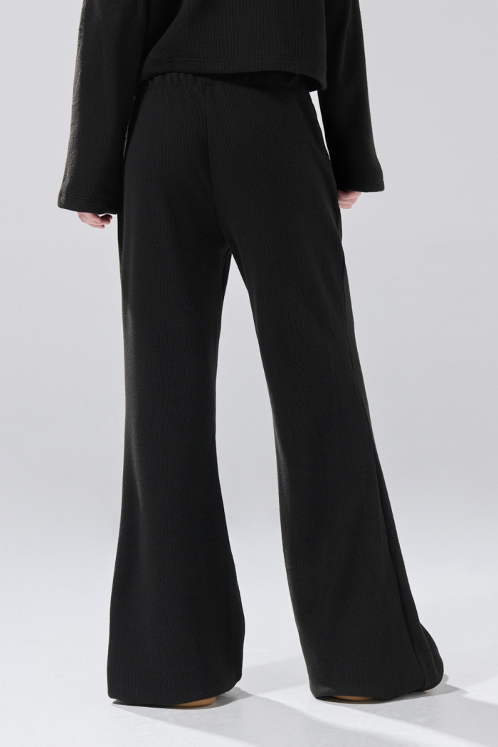 Pantalón unicolor flare con bota ancha y texturas
