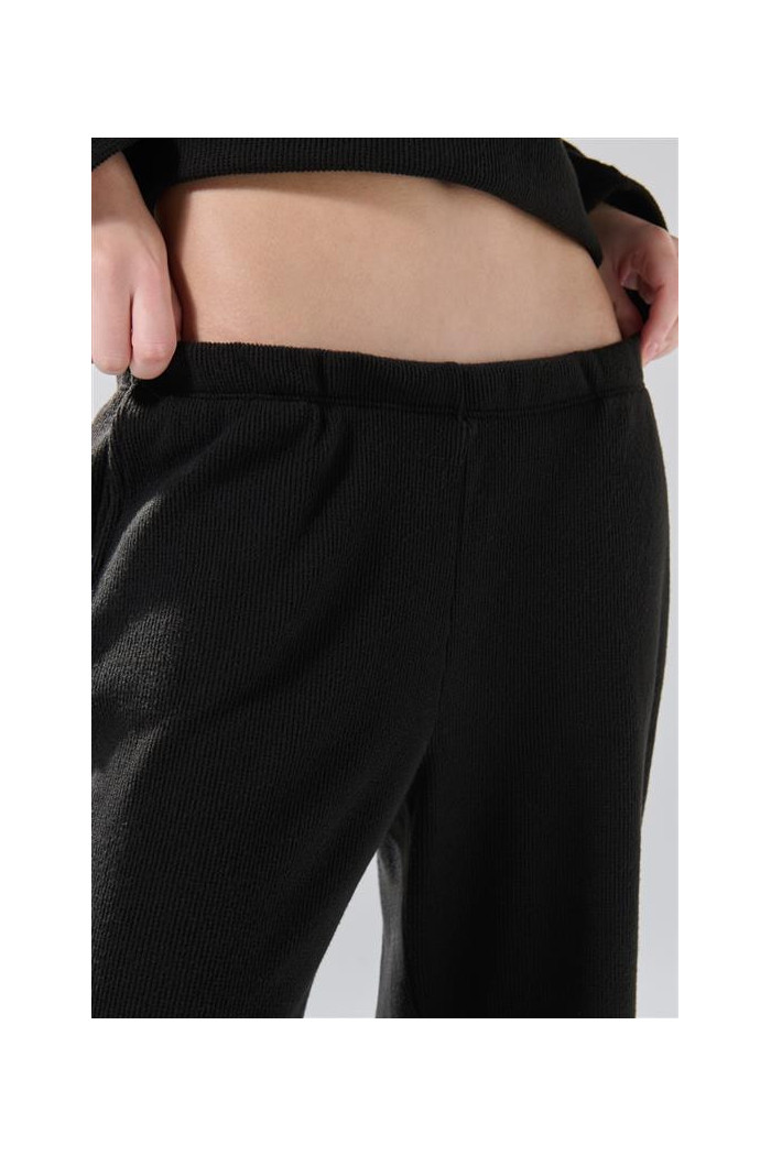 Pantalón unicolor flare con bota ancha y texturas
