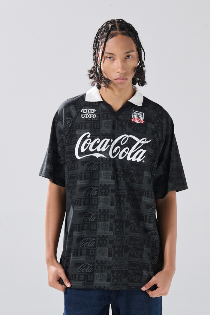 Camiseta negra con estampados de Coca-Cola y cuello polo
