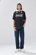Camiseta negra con estampados de Coca-Cola y cuello polo
