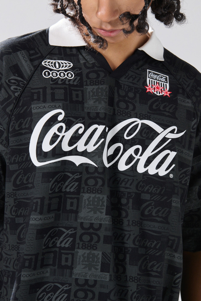 Camiseta negra con estampados de Coca-Cola y cuello polo

