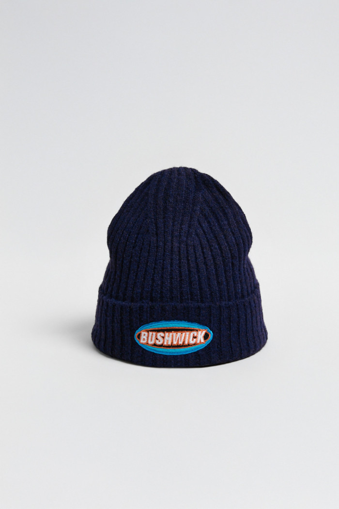 Gorro tejido unicolor con texto en frente y finas texturas
