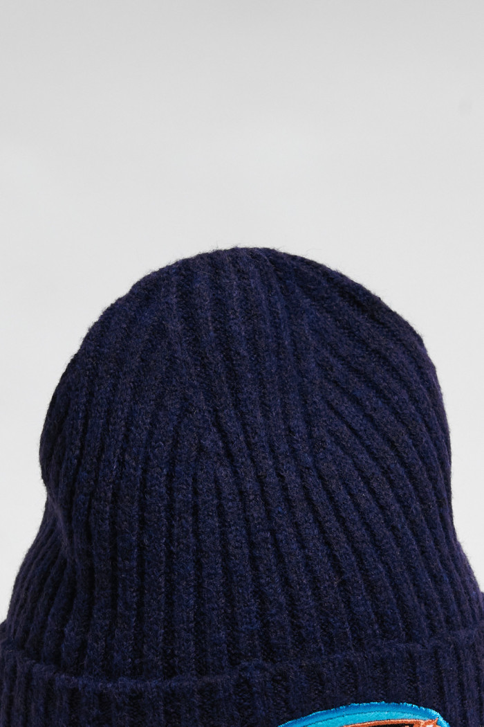 Gorro tejido unicolor con texto en frente y finas texturas
