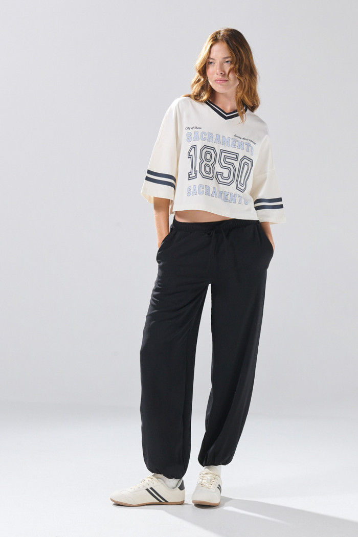 Camiseta oversize crop top crema con cuello V y arte college
