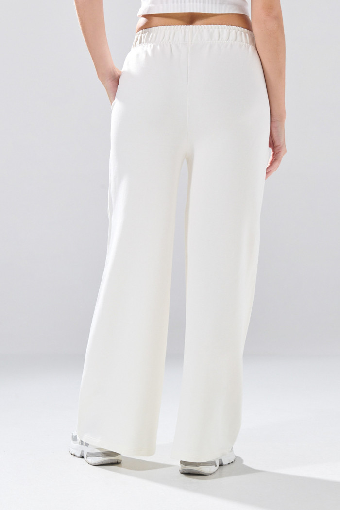 Pantalón unicolor jogger con bolsillos laterales y bota ancha
